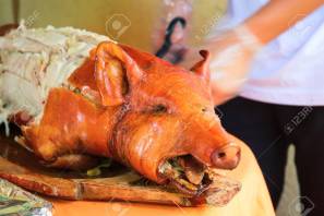 87837188-fried-pork-on-table-waiter-cut-whole-pork-traditional-dish-whole-roasted-pig-with-head-delicious-mea.jpg